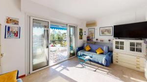 ein Wohnzimmer mit einem Sofa und einem Flachbild-TV in der Unterkunft Résidence Le Garavan Beach - Studio pour 4 Personnes 614 in Menton
