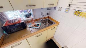 eine kleine Küche mit einer Spüle und einer Mikrowelle in der Unterkunft Résidence Le Garavan Beach - Studio pour 4 Personnes 614 in Menton