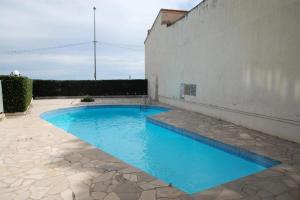una piscina in un patio con acqua blu di Résidence Hawai - 2 Pièces pour 4 Personnes 644 a Mentone
