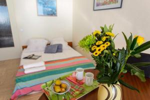 een slaapkamer met een bed en een tafel met een vaas met bloemen bij Résidence Hawai - 2 Pièces pour 4 Personnes 644 in Menton