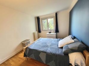 a bedroom with a bed and a window in it at Appartement Paris Sud 53m2 - 2 chambres in Malakoff