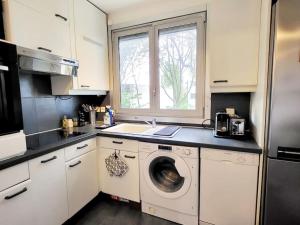 a kitchen with a sink and a washing machine at Appartement Paris Sud 53m2 - 2 chambres in Malakoff