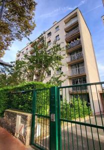 budynek z zieloną bramą przed budynkiem w obiekcie Appartement Paris Sud 53m2 - 2 chambres w mieście Malakoff