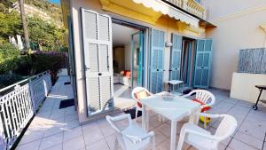een patio met een tafel en stoelen op een balkon bij Résidence Villa Louise - 2 Pièces pour 4 Personnes 584 in Menton