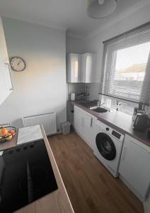 a kitchen with a washing machine and a sink at Jacob's Place - rural location in Lanark