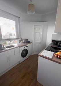 uma cozinha com um lavatório e um fogão forno superior em Jacob's Place - rural location em Lanark