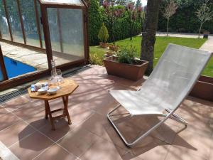 une chaise blanche et une table sur une terrasse dans l'établissement Casa Alborada, à Cercedilla