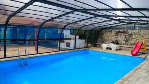 an outdoor swimming pool with a metal roof and a swimming poolvisor at Casa Alborada in Cercedilla