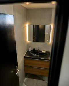 a bathroom with a sink and a mirror at Appartement vue montagnes in Gap