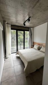 a bedroom with a bed and a large window at Las Marias Apart I in Necochea