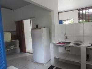 eine Küche mit einem weißen Kühlschrank und einer Spüle in der Unterkunft Sítio Colina Eventos in Santo Antônio do Rio das Pedras