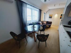 salon ze szklanym stołem i krzesłami w obiekcie Komfortowe nowe mieszkanie, duży taras w Krakowie