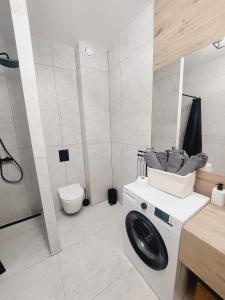 a white bathroom with a toilet and a sink at Komfortowe nowe mieszkanie, duży taras in Krakow