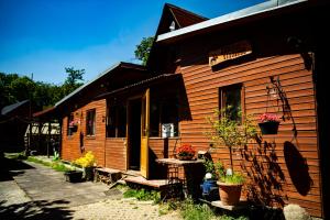 a wooden house with potted plants in front of it at Ranč Skalka in Rousínov