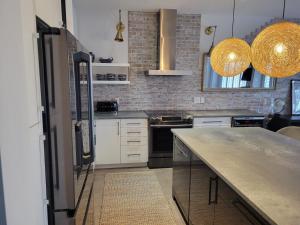 a kitchen with white cabinets and a counter top at Exclusive Townhome near West-Side Trails in Waterloo