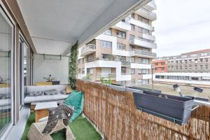 Cet appartement dispose d'un balcon avec un canapé et une grande fenêtre. dans l'établissement Beautiful and bright 3 bed near La Villette, à Paris