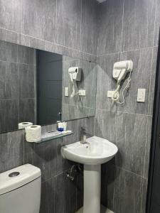 uma casa de banho com um lavatório, um espelho e um WC. em Deluxe Room em Angeles