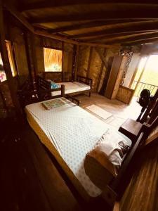 a bedroom with two beds in a wooden cabin at Casa Komerio in Palomino