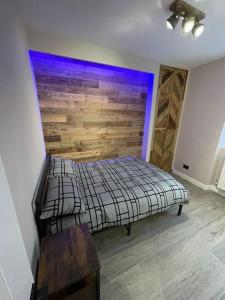 a bedroom with a bed with a wooden wall at 1bedroom ground floor apartment in Aberdeen