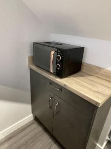 a black microwave sitting on top of a counter at 1bedroom ground floor apartment in Aberdeen
