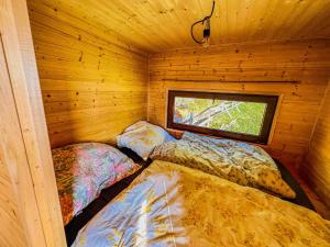 a room with two beds in a wooden cabin at Ranč Skalka in Rousínov