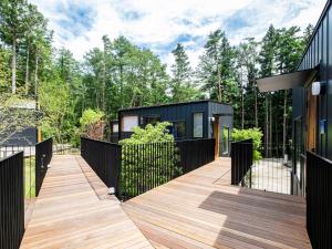 een zwart huis met een houten terras bij FJ Forest - Vacation STAY 37804v in Fujikawaguchiko