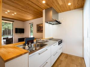een keuken met witte kasten en een houten plafond bij FJ Forest - Vacation STAY 37804v in Fujikawaguchiko