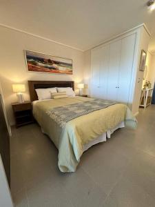 a bedroom with a large bed with two lamps at Depto. frente al Mar - Costa Higuerillas in Concón