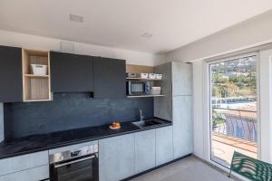 une cuisine avec un comptoir noir et une fenêtre dans l'établissement Résidence Le Garavan Beach - 3 Pièces pour 5 Personnes 304, à Menton