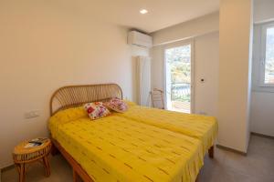- une chambre avec un lit jaune et une couverture jaune dans l'établissement Résidence Le Garavan Beach - 3 Pièces pour 5 Personnes 304, à Menton