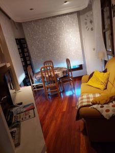 un soggiorno con divano, tavolo e sedie di Alojamiento en TORRE SOLOKOETXE License LBI227 a Bilbao