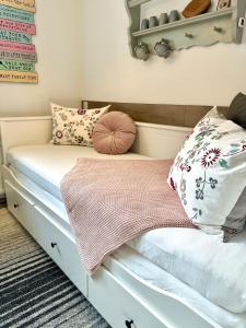 una piccola camera da letto con un letto con cuscini sopra di Helle Ferienwohnung Saunahaus ad Annaberg im Lammertal