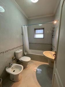 y baño con aseo, bidet y lavamanos. en Comfortable family apt - 1002 en Amán