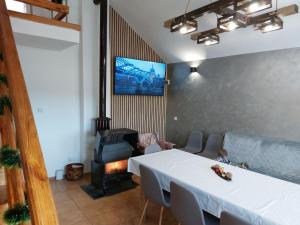uma sala de estar com uma mesa e uma lareira em Къща за гости Балканъ em Kyustendil