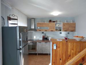 a kitchen with a stainless steel refrigerator and wooden cabinets at Къща за гости Балканъ in Kyustendil