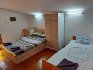 um quarto com 2 camas individuais e um armário em Къща за гости Балканъ em Kyustendil