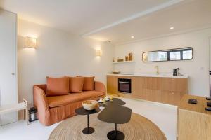 a living room with a couch and a table at HSH Blonville/Deauville : Magnifique maison avec jardin in Blonville-sur-Mer +3 photos