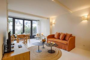 a living room with a couch and a table at HSH Blonville/Deauville : Magnifique maison avec jardin in Blonville-sur-Mer