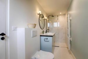 a bathroom with a toilet and a sink and a mirror at HSH Blonville/Deauville : Magnifique maison avec jardin in Blonville-sur-Mer