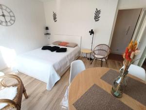 um quarto com uma cama branca e uma mesa em Résidence Montcalm C - Studio pour 2 Personnes 004 em Aix-les-Bains