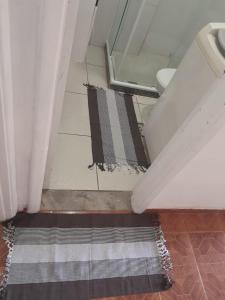 uma casa de banho com um chuveiro e um tapete no chão em studio no Rio de Janeiro