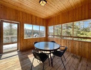 a dining room with a table and chairs in a cabin at The Bear Cave Cottage at Little Kennisis Lake in Algonquin Highlands