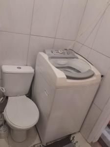 uma casa de banho com um WC branco e um lavatório. em studio no Rio de Janeiro