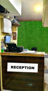 una oficina con una recepción con una pared verde en HOTEL AIRPORT HEAVEN en kolkata