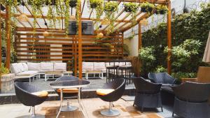 a patio with chairs and a table and a pergola at Cata Apartment Hotel And Spa in Ikeja