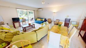 uma sala de estar com um sofá amarelo e uma mesa em Résidence Les Miradors - 3 Pièces pour 6 Personnes 524 em Menton