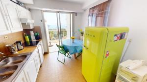 um frigorífico verde numa cozinha com uma mesa em Résidence Les Miradors - 3 Pièces pour 6 Personnes 524 em Menton