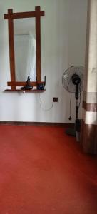 a room with a red floor and a fan at Ella Shali's home in Ella