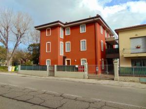 un edificio rosso sul lato di una strada di SE043 - Senigallia, nuovo trilocale accessoriato a 100 mt dal mare a Senigallia
