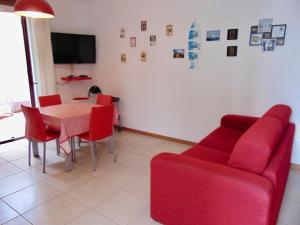 un soggiorno con tavolo e divano rosso di SE043 - Senigallia, nuovo trilocale accessoriato a 100 mt dal mare a Senigallia
